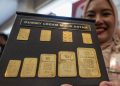 Petugas menunjukkan dumi logam mulia produksi Antam. (Foto Basri Marzuki/Antara)