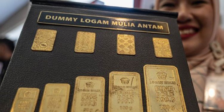 Petugas menunjukkan dumi logam mulia produksi Antam. (Foto Basri Marzuki/Antara)